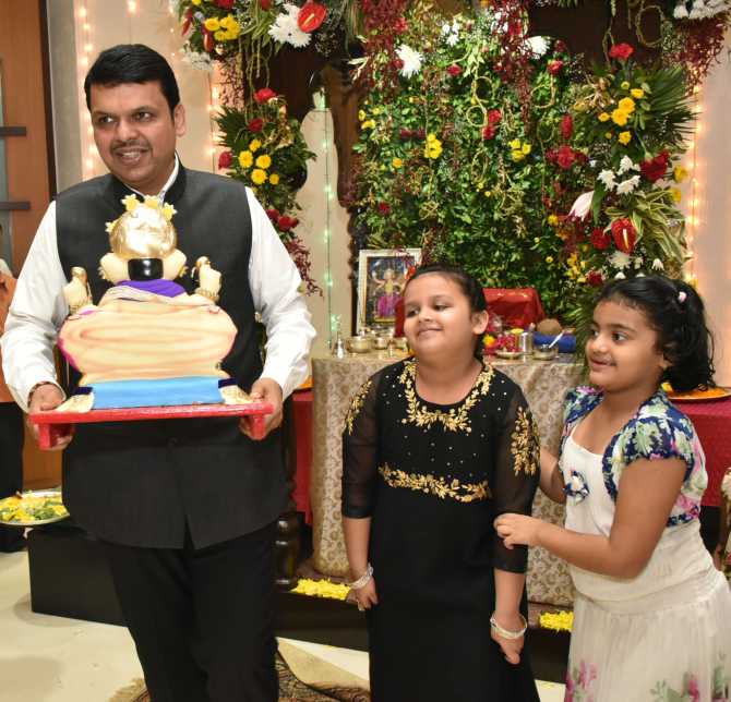 Maharashtra Chief Minister Devendra Fadnavis during Ganeshotsav with his daughter Divija (centre) and her friend on his way to Ganpati immersion at Girgaon Chowpaty