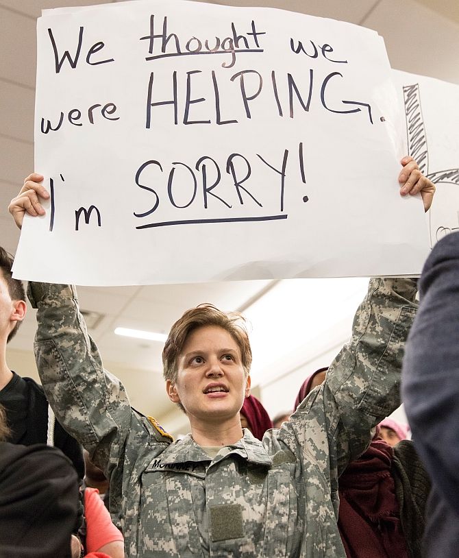 A US military veteran holds a sign as people protest Donald Trump's travel ban at Dallas/Fort Worth International Airport, Dallas, Texas, January 29, 2017. Photograph: Laura Buckman/Reuters
