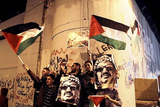 Palestinians with posters of the late Palestinian leader Yasser Arafat and Palestinian flags during a rally