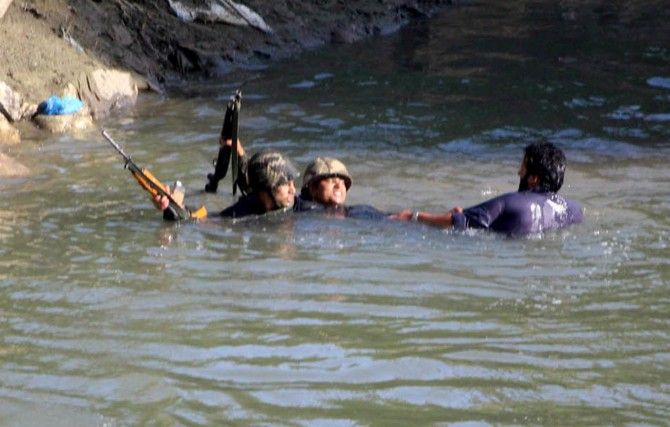 Soldiers capture a stone pelter from a lake around the encounter site in Kashmir, June 16, 2017. Photograph: Umar Ganie