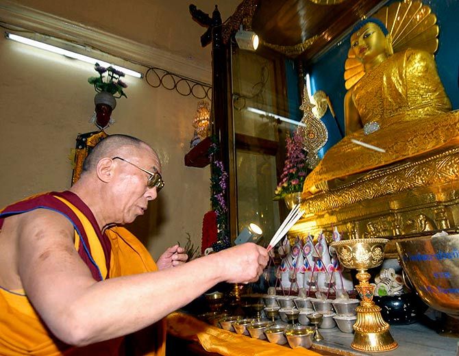 The Dalai Lama worships inside a monastery at Bodh Gaya.