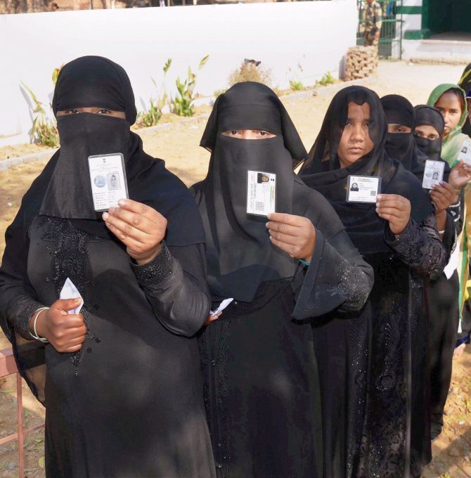 Muslim women queue up at a polling booth