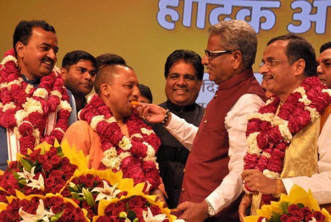 BJP General Secretary O P Mathur feeds Yogi Adityanath a sweet after his election as leader of the BJP legislature party in UP, March 18, 2017, as Deputy Chief Ministers-elect Keshav Prasad Maurya, left, and Dr Dinesh Sharma, right, look on. Photograph: Sandeep Pal
