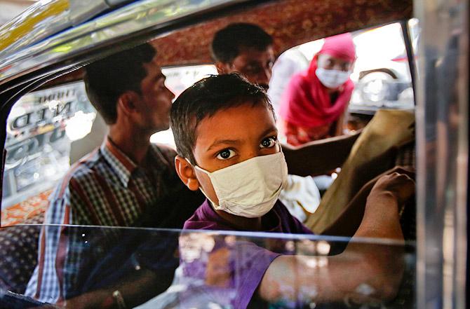 Cancer patients Aryan Khan, front and Areena Bibi, rear, in a taxi window outside Tata Memorial Centre Mumbai. Photo: Vivek Prakash/REUTERS