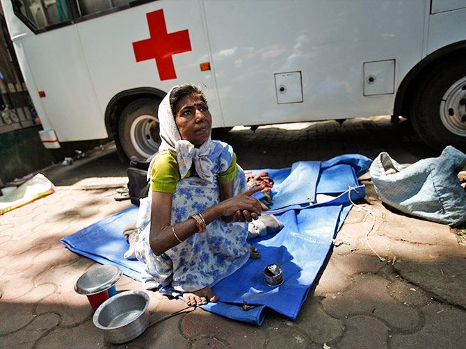 A woman with cancer sits on a pavement outside the Tata Memorial Centre. Photograph: Vivek Prakash/Reuters