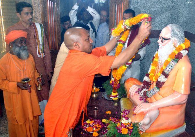 Uttar Pradesh Chief Minister Yogi Adityanath garlands his mentor Mahant Avaidyanath's statue in Gorakhpur. Photograph: PTI Photo