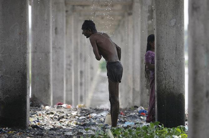 The area below a leaking water pipeline is a man's bathroom in New Delhi, September 13, 2009. Photo: Parth Sanyal/Reuters