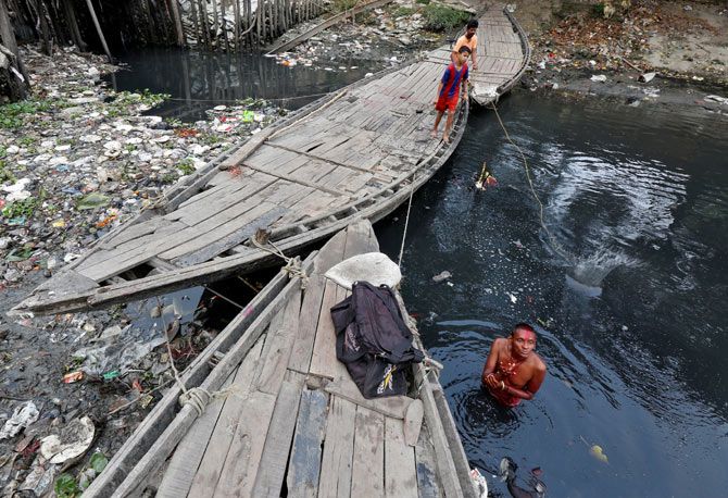 A man offers a prayer as he takes a dip in the waters of Tolly's Nullah in Kolkata, March 22, 2017. Photo: Rupak De Chowdhuri/Reuters