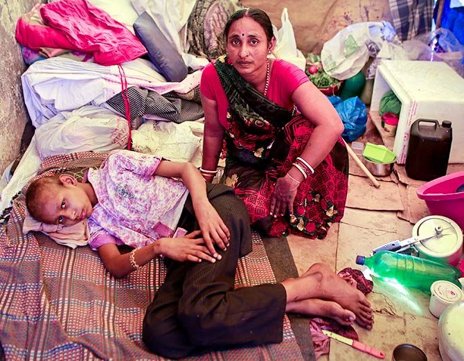 In this photograph shot on March 4, 2013, Raj Kishore Kumar, a 12-year-old cancer patient, rests with his mother inside his pavement dwelling outside the Tata Memorial Hospital in Mumbai. Photograph: Danish Siddiqui/Reuters