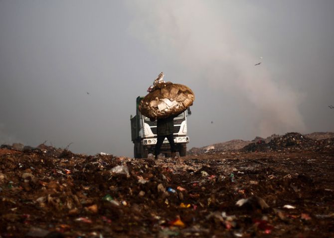 A man carries a sack of recyclable material at a garbage dump in New Delhi February 2, 2014. Photo: Adnan Abidi/Reuters