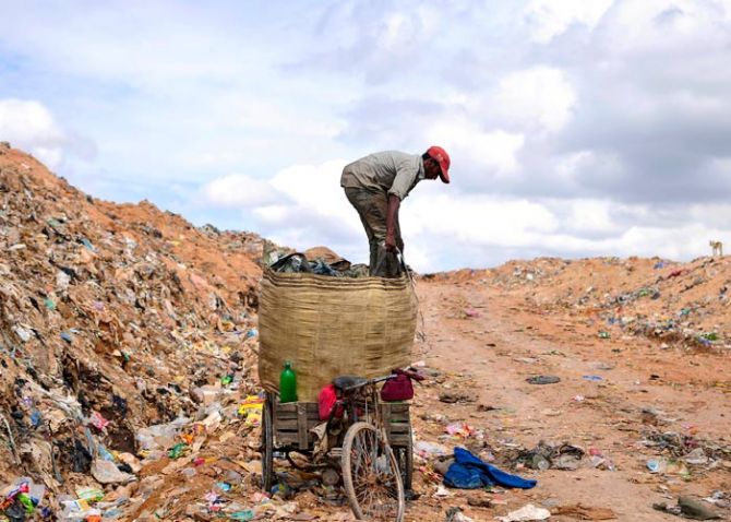A rag picker prepares to pack a sack filled with recyclable materials, mounted on his tricycle at a garbage dump on the outskirts of the southern Indian city of Bangalore August 26, 2014. Photo: Abhishek N Chinnappa/Reuters