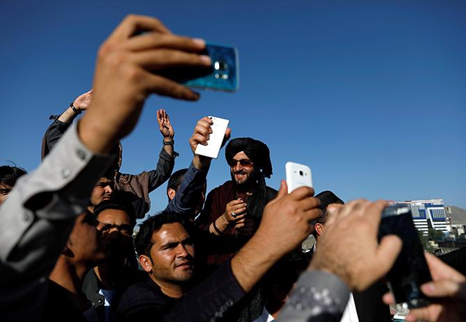 Afghans take pictures with a Taliban in Kabul, June 16, 2018. Photograph: Mohammad Ismail/Reuters