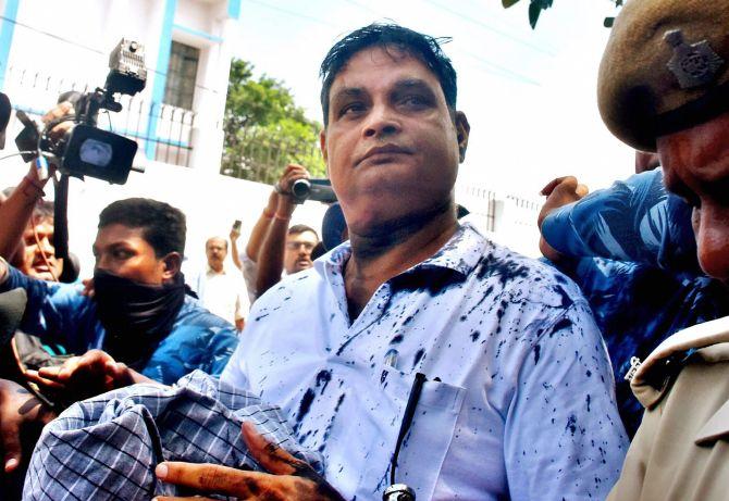 Brajesh Thakur, the main accused in the Muzaffarpur shelter home case, after a woman threw ink on his face while he was being taken to a special court in Muzaffarpur, August 8, 2018. Photograph: PTI Photo