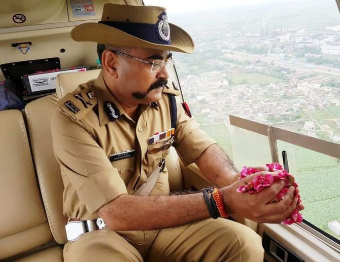 Uttar Pradesh's Additional Director General of Police - Meerut Zone Prashant Kumar showers rose petals on kanwariyas while on surveillance duty in a helicopter. Photograph: ANI