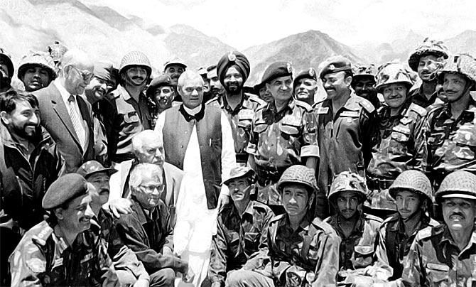 Then prime minister Atal Bihari Vajpayee along with then defence minister George Fernandes, crouching, third from left, then Jammu and Kashmir governor Girish Chandra 'Gary' Saxena, standing second from left, and then army chief General Ved Prakash Malik, fourth from right, meet the troops in Kargil.