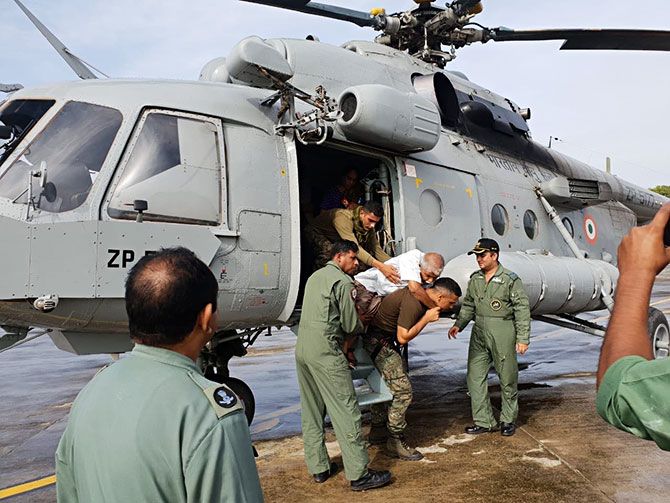 Elderly being carried by IAF personnel