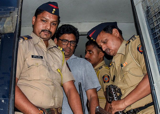 Social activist-lawyer Arun Ferreira is brought back to his home and placed under house arrest in Thane. Photograph: PTI Photo