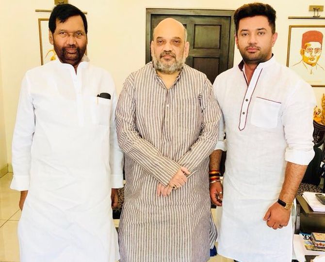 Ram Vilas Paswan, left and his son Chirag Paswan, right, flank Bharatiya Janata Party national President Amit Anilchandra Shah.