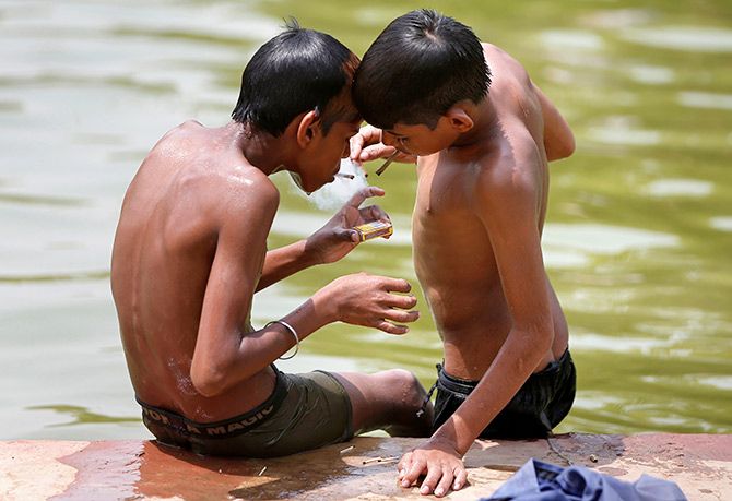 Young boys smoke a bidi. Photograph: Amit Dave/Reuters