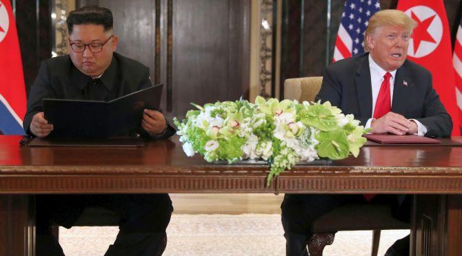 US President Donald J Trump addresses the media while North Korean leader Kim Jong Un looks at the signed document that acknowledges the progress of the talks after their summit at the Capella Hotel, Singapore. Photograph: Jonathan Ernst/Reuters