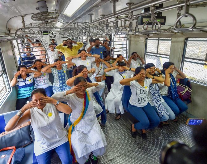 Commuters practise yoga in a local train in Mumbai.