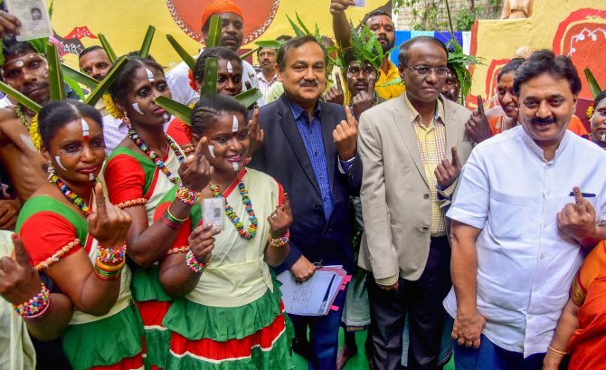Karnataka Chief Electoral Officer Sanjiv Kumar with Siddi tribe members show their fingers marked with indelible ink during a voting awareness campaign ahead of the Karnataka assembly election in Bengaluru, May 10, 2018. Photograph: PTI Photo