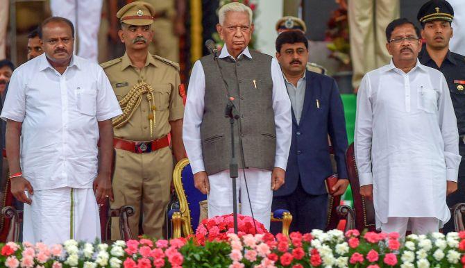 Karnataka Chief Minister H D Kumaraswamy, Governor Vajubhai Vala, Deputy Chief Minister G Parameshwara after the swearing-in ceremony, May 24, 2018. Photograph: Shailendra Bhojak/PTI Photo