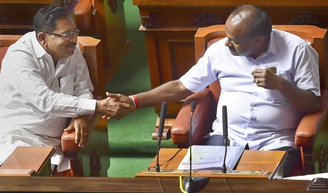 Karnataka Chief Minister H D Kumaraswamy, right,  and Deputy Chief Minister G Parameshwara congratulate each other after the Janata Dal-Secular-Congress government won the vote of confidence in the state assembly, May 25, 2018. Photograph: Shailendra Bhojak/PTI Photo