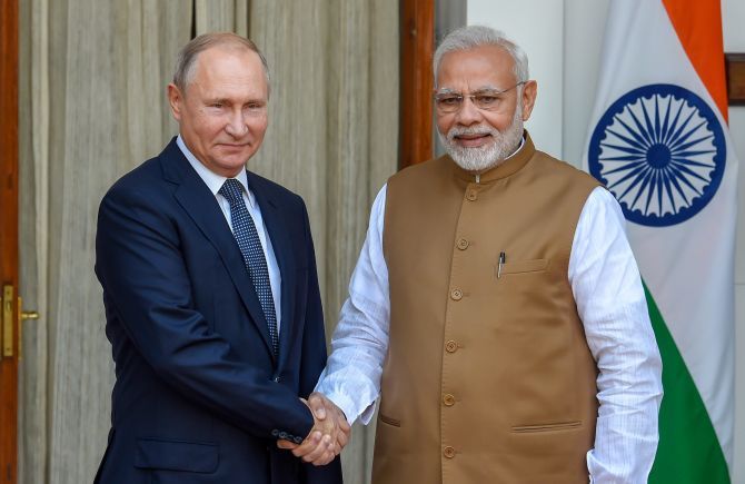 Russian President Vladimir Putin shakes hands with India's Prime Minister Narendra Modi