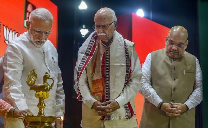 Prime Minister Narendra Damodardas Modi lights a lamp as BJP President Amit Anilchandra Shah and party Margdarshak Mandal member Lal Kishenchand Advani look on before the BJP national executive meeting in New Delhi, September 8, 2018. Photograph: Atul Yadav/PTI Photo