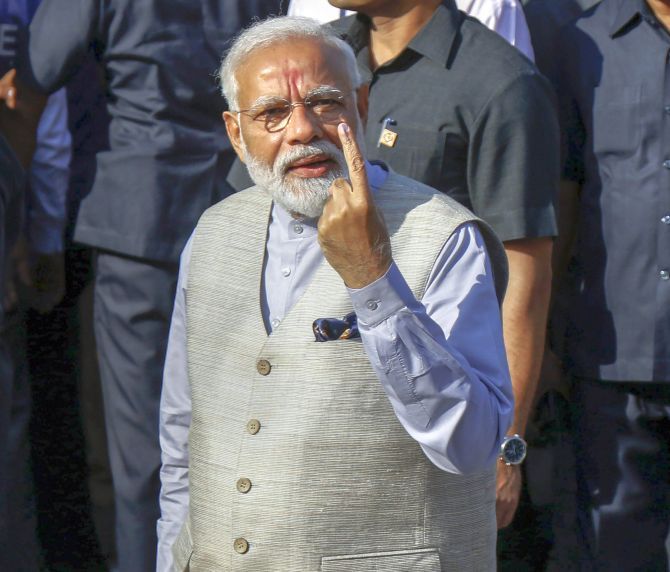 Prime Minister Narendra Damodardas Modi shows his inked finger after casting his vote at a polling station in Ahmedabad, April 23, 2019. Photograph: PTI Photo