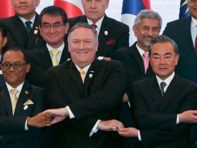 U.S. Secretary of State Mike Pompeo crosses his arms for the traditional ASEAN handshake with Chinese Foreign Minister Wang Yi and other fellow diplomats during the 26th ASEAN Regional Forum (ARF) in Bangkok