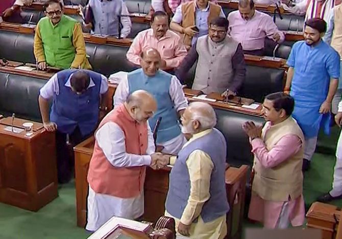  Prime Minister Narendra Modi shakes hands with Union Home Minister Amit Shah after Parliament approved the abrogation of Article 370