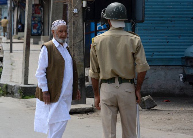  An elderly man seeks permission to go forward amid curfew in Srinagar.