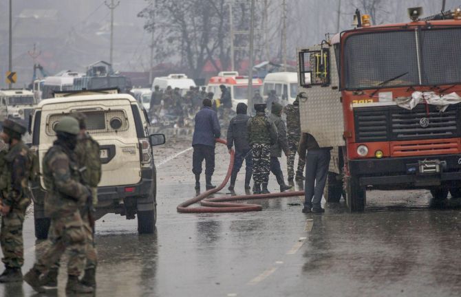 Firemen spray water to wash away blood stains at the site of the suicide bomb attack at Lathepora Awantipora in south Kashmir's Pulwama district, February 14, 2019. Photograph: PTI Photo