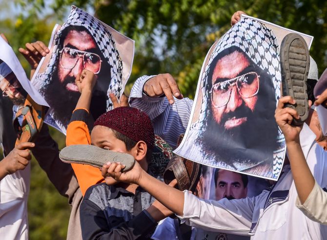 Protesters beat posters of Jaish-e-Mohammed terrorist Masood Azhar in Ahmedabad, February 15, 2019. Photograph: Santosh Hirlekar/PTI Photo