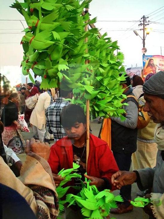 A boy sells parrots replicas at the Kumbh