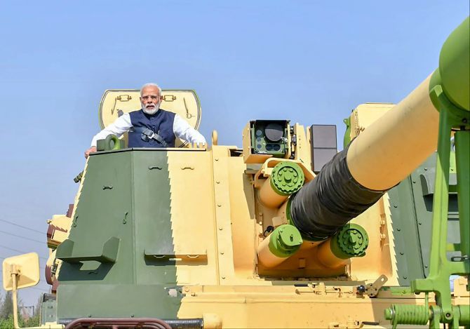 Prime Minister Narendra Damodardas Modi rides a tank at Larsen and Toubro's Armoured Systems Complex facility at Hazira, Surat, January 19, 2019. Photograph: Press Information Bureau