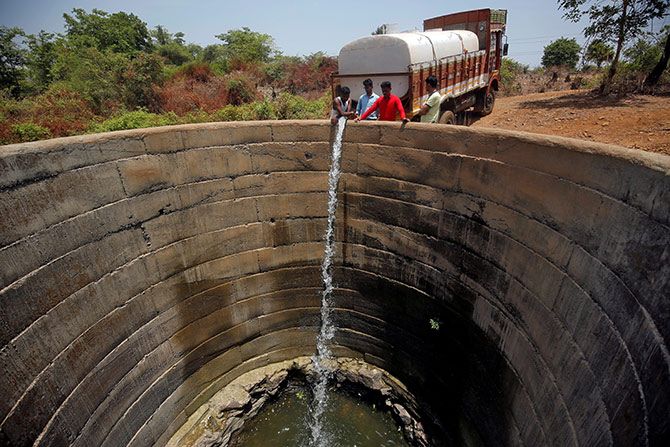 A dried-up well is refilled with water from a water tanker in Thane district in the western state of Maharashtra. Photograph: Francis Mascarenhas/Reuters.  