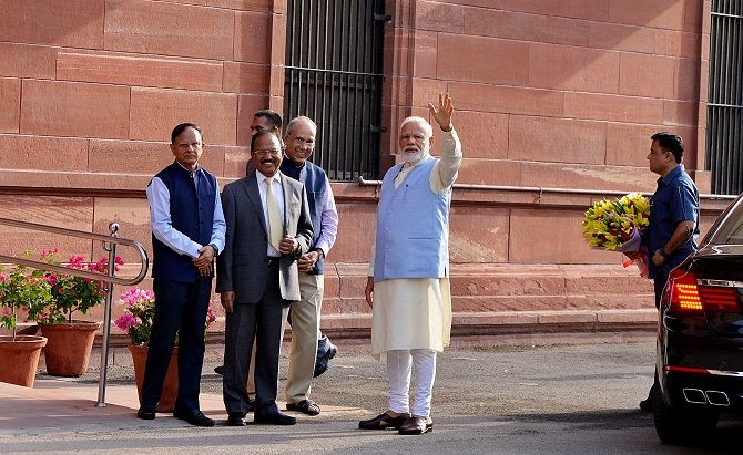 IMAGE: Prime minister's office staff receive Prime Minister Narendra Damodardas Modi as he arrives for a Cabinet meeting in New Delhi.