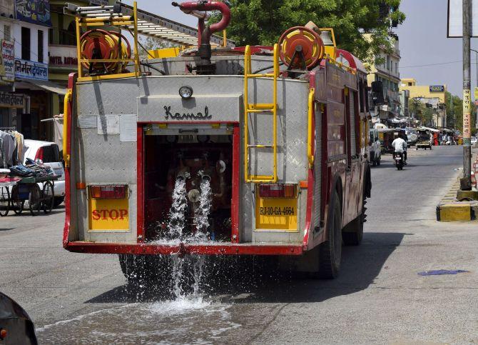 A fire brigade vehicle waters a road in Churu. Photograph: PTI Photo