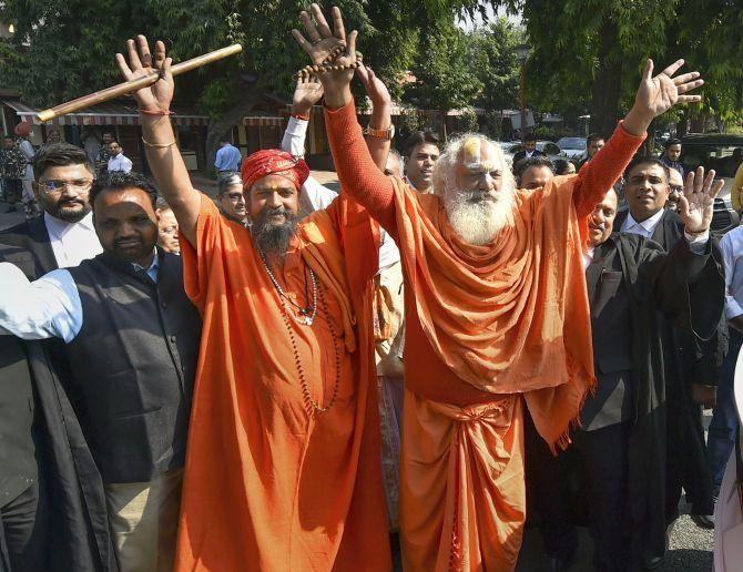 Mahant Dharam Das of the Nirwani Akhara along with advocates react after the verdict in New Delhi