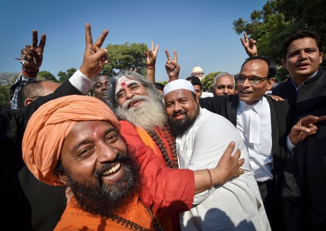 People belonging to Hindu and Muslim faiths celebrate the verdict in the Ayodhya case outside the Supreme Court in New Delhi.