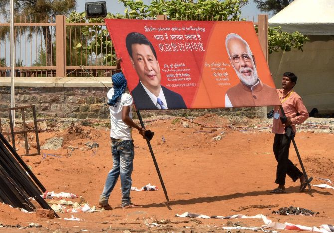 Workers carry a hoarding welcoming Prime Minister Narendra Damodardas Modi and Chinese President Xi Jinping in Mahabalipuram. Photograph: PTI Photo