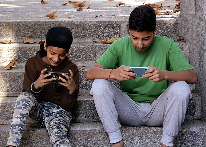 Children take to their mobile phones after postpaid mobile phones without internet were restored in Kashmir