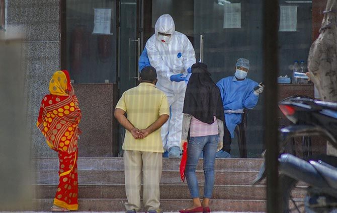 Medics attend to people arriving for COVID-19 tests at the Hallet Hospital in Kanpur. Photograph: PTI Photo
