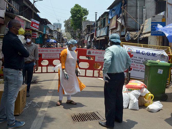 Medical and healthcare personnel enter the Jijamata Nagar area on Worli, south central Mumbai, April 13, 2020. Photograph: Arun Patil