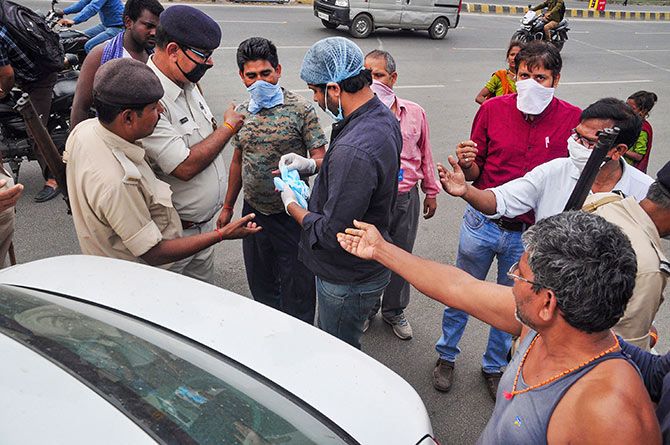 Masks being distributed on a street in Patna. Photograph: PTI Photo