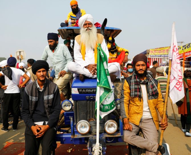 Farmers sit on a tractor during a protest