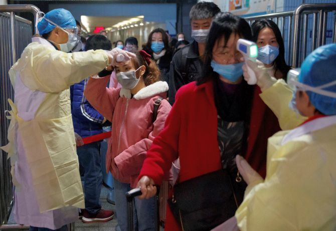 Medical workers check the temperature of passengers who alighted from a train in Jiujiang, Jiangxi province, China.